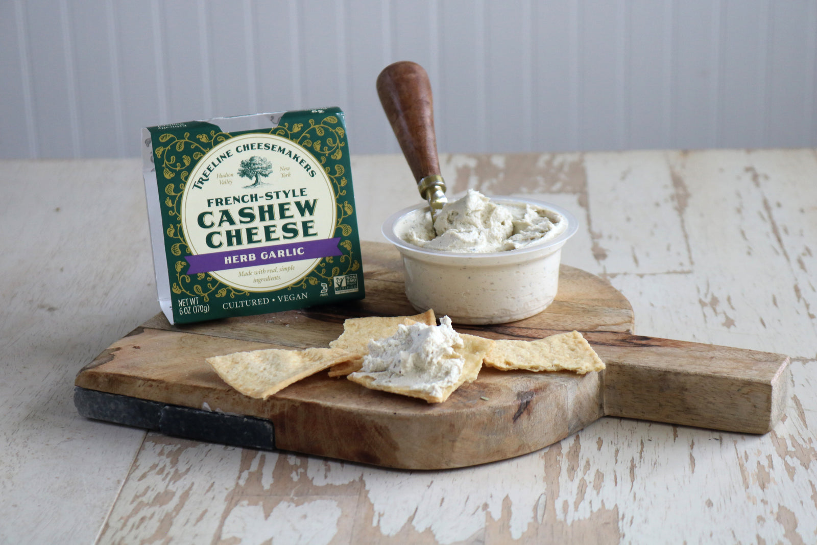 vegan herb garlic cheese on a board with crackers
