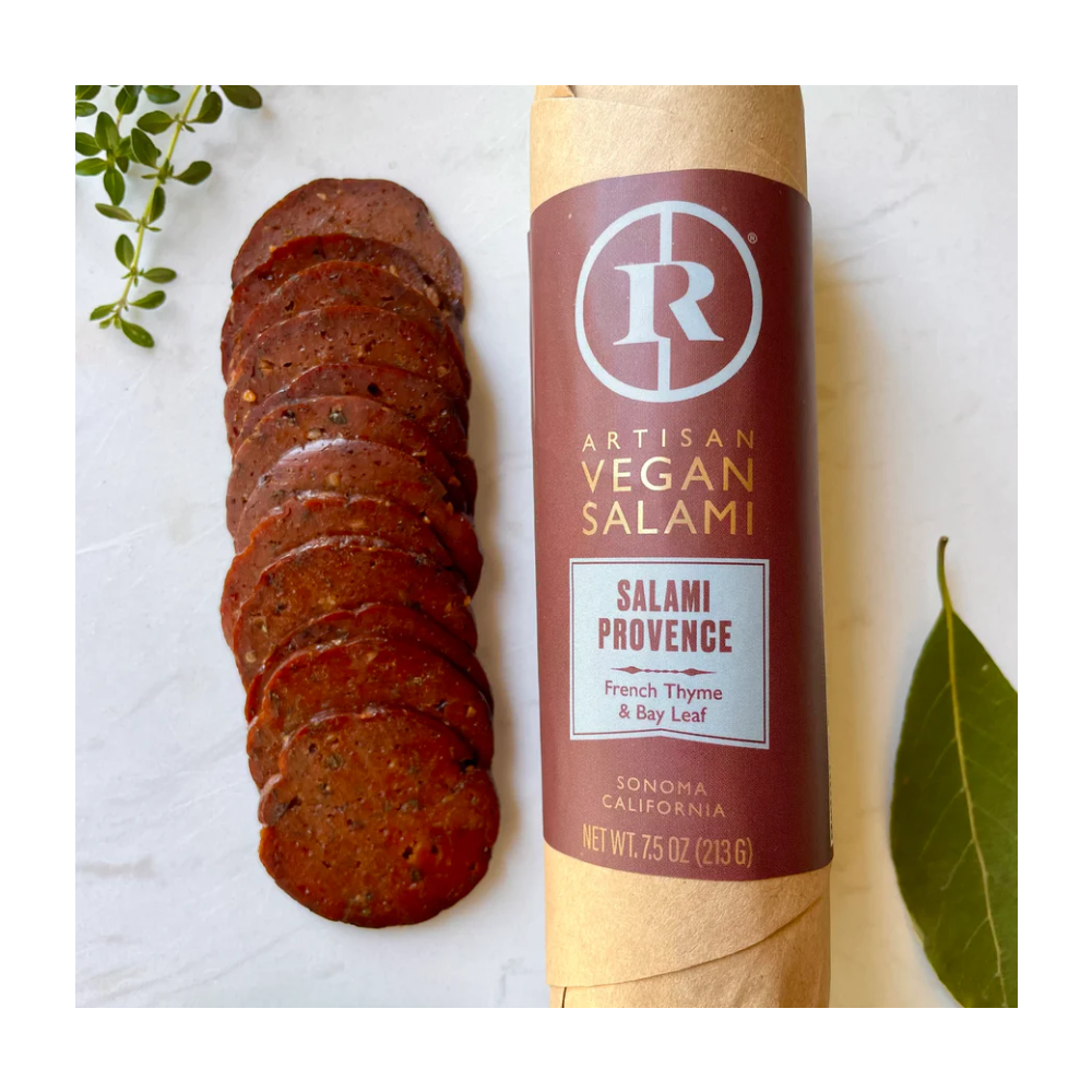 Renegade Artisan Vegan Salami with thyme and bay leaf on a white background