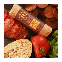 Vegan salami with bread, tomatoes, and lettuce on a dark surface