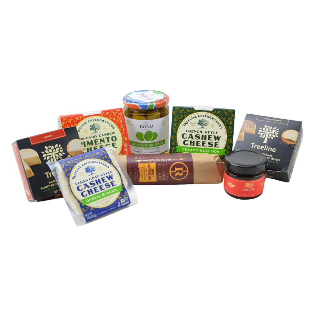 a photo of 5 vegan cheeses, 1 salami, a jar of olives, and a jar of fig jam on a white background